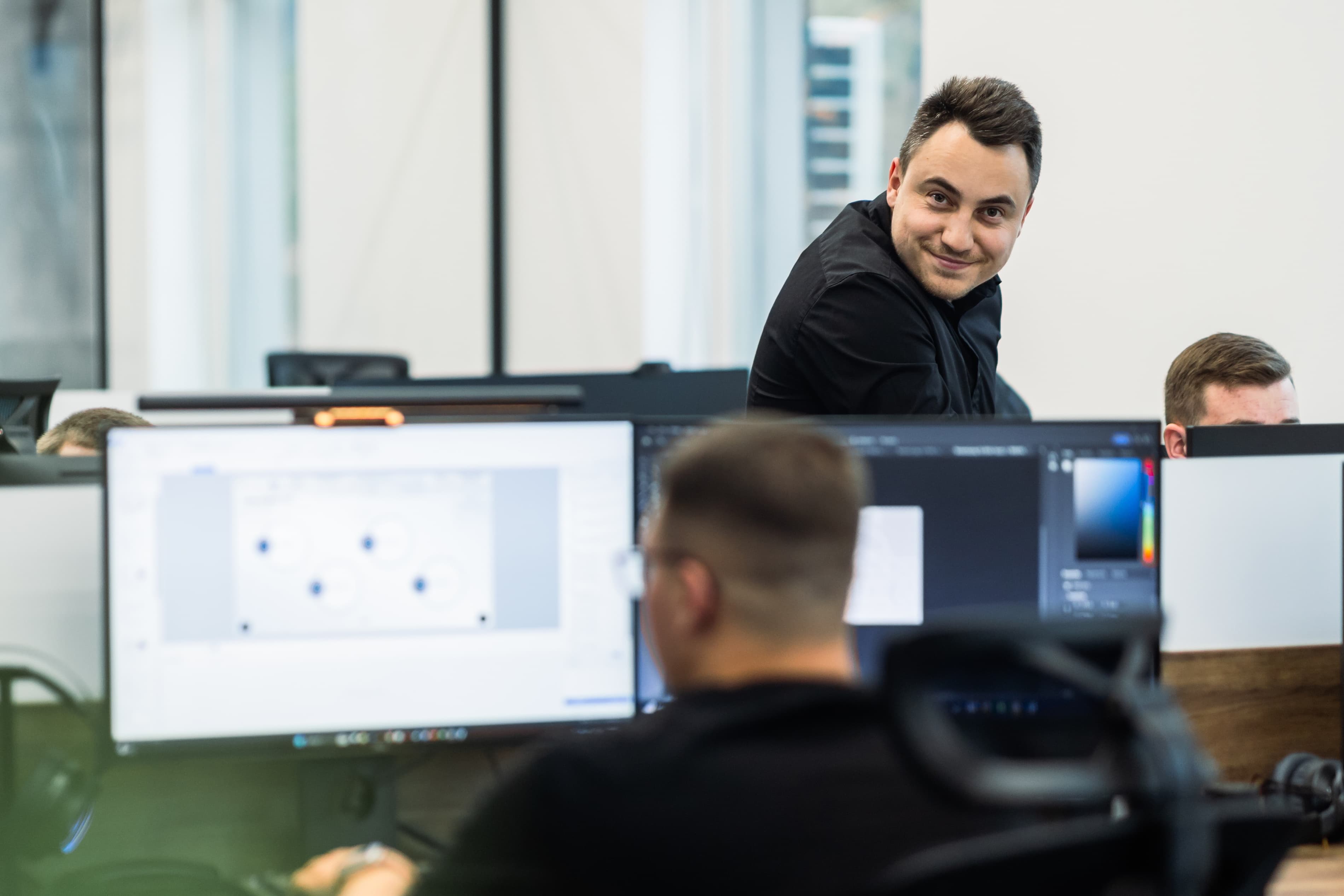 The e-Perfection studio: colleagues at their desks, one of them turning toward the camera.